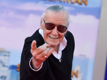 Stan Lee poses like Spider-Man during the premiere of Spider-Man: Homecoming.